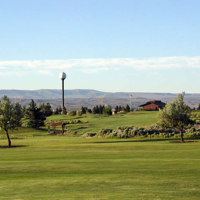 shot of a golf fairway in wyoming, brown mountain in background